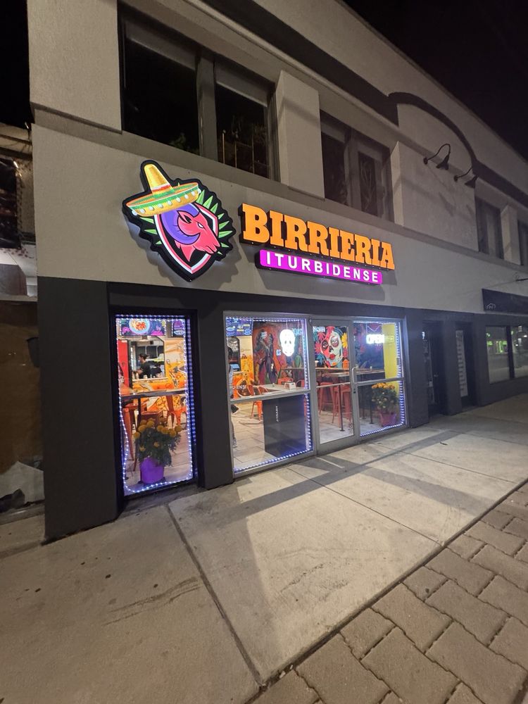 The Birriería Iturbidense storefront lit up at night in Broad Ripple